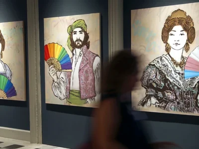 Sala del Museu de la Ciutat amb obres de l’exposició València Queer i una persona desenfocada en primer terme