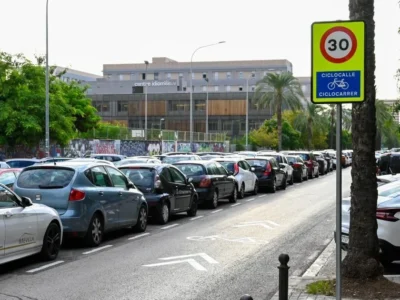 Carrer de València amb senyalització ciclista i vehicles estacionats.