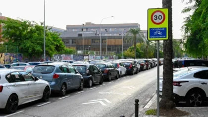 Carrer de València amb senyalització ciclista i vehicles estacionats.