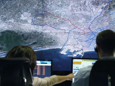 Dos operadors davant d'un mapa digital de València en un centre de control de l'abastiment d'aigua